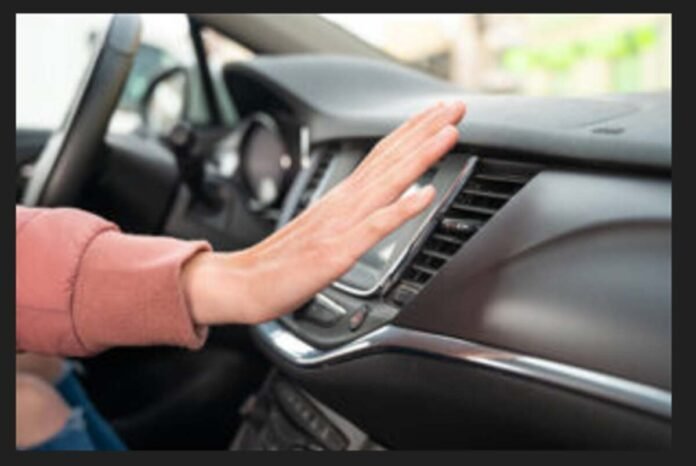 Mechanic inspecting a car's air conditioning system to find the cause of poor cooling